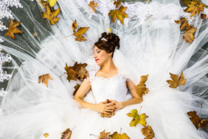 abito da sposa circondato da foglie di quercia essicate