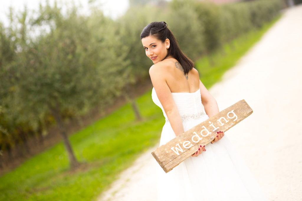 sposa che tiene in mano il cartello con scritto wedding